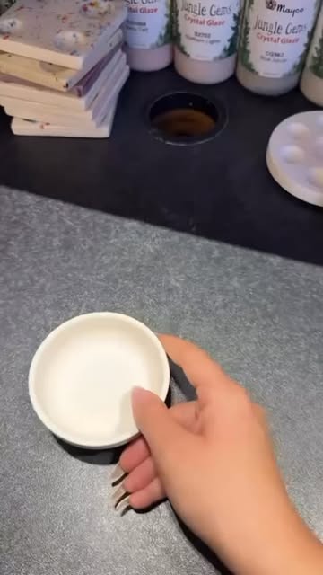 Unbemalte kleine Keramikschale am Maltisch mit Glasurfarben und Palette